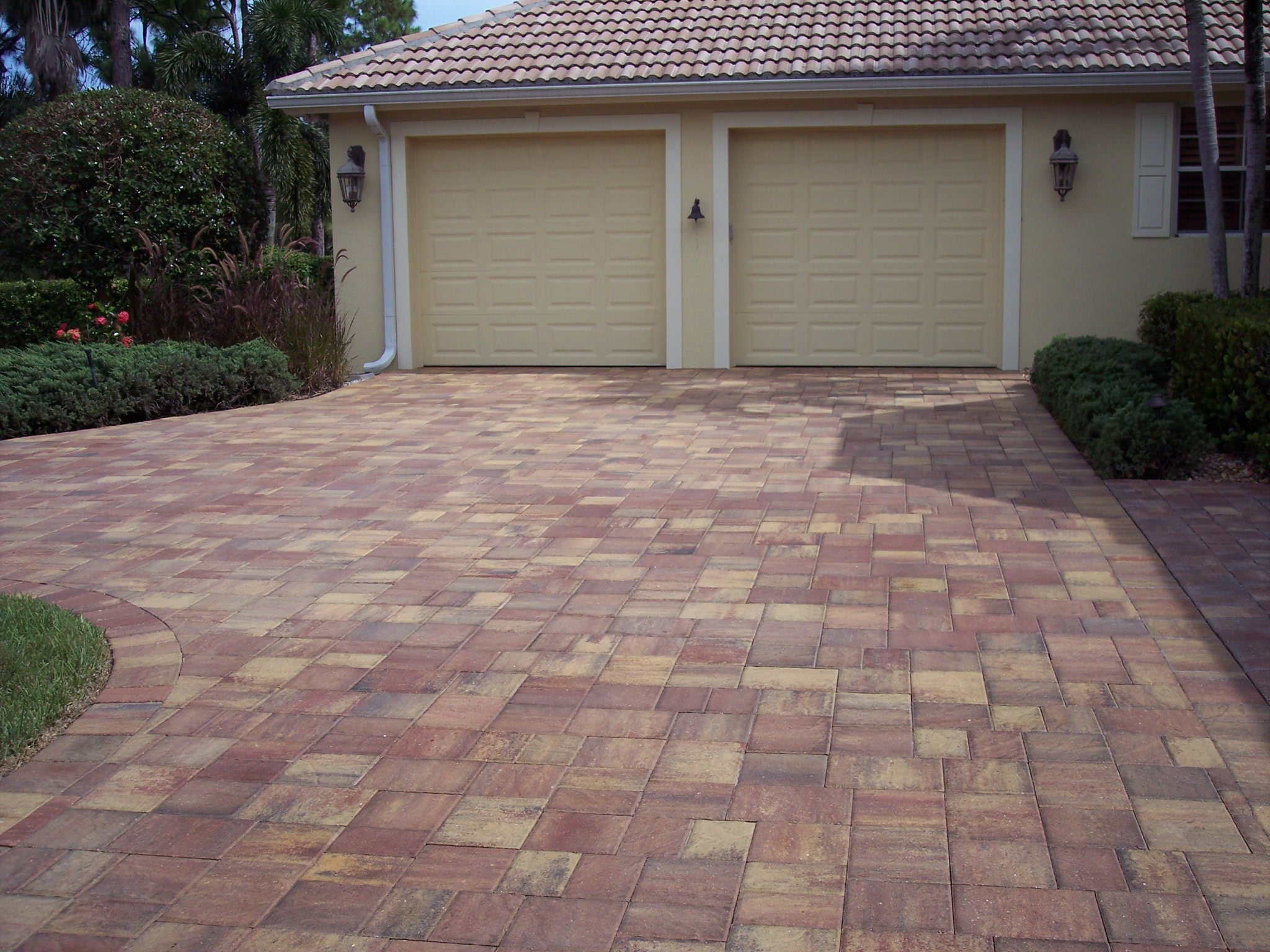 Warm blended pavers leading to a two-car garage