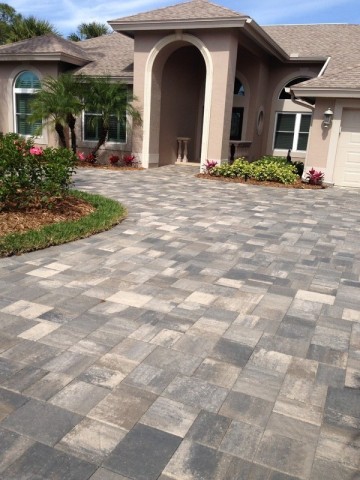 Gray blended paver driveway with a curved landscaped edge
