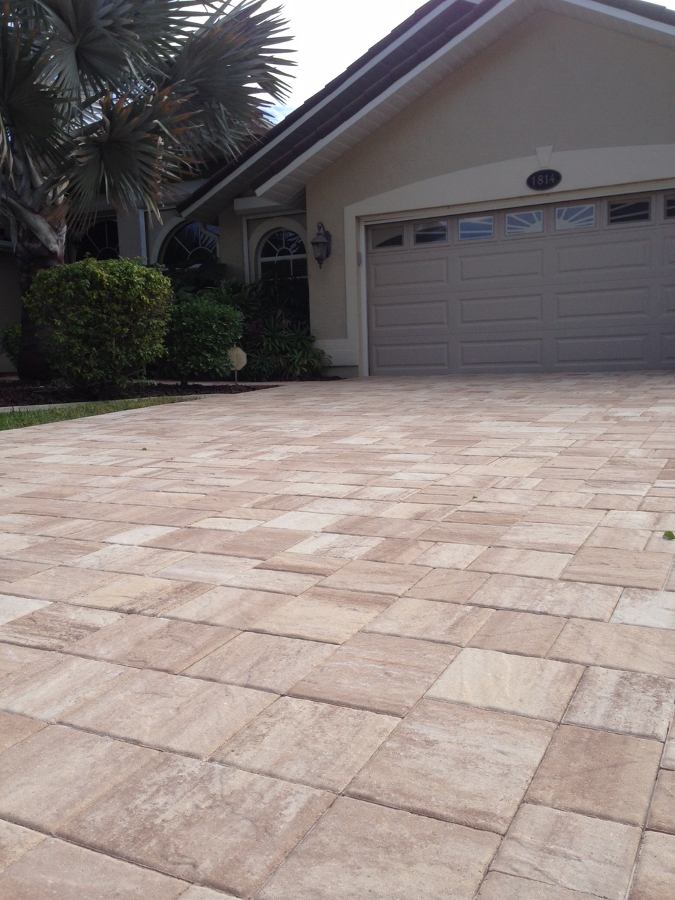 Light beige blended pavers on a driveway leading to a garage